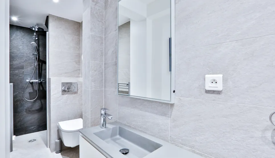 Luxury modern bathroom: walk-in shower, designer sink, wall-hung toilet, elegant tiling. High-end finishes for an exceptional property.