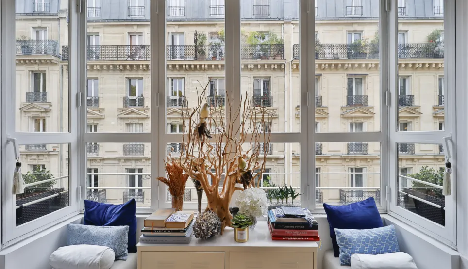 Luxury Parisian apartment: bright reading nook with stunning view of Haussmann buildings. Elegant and refined design.