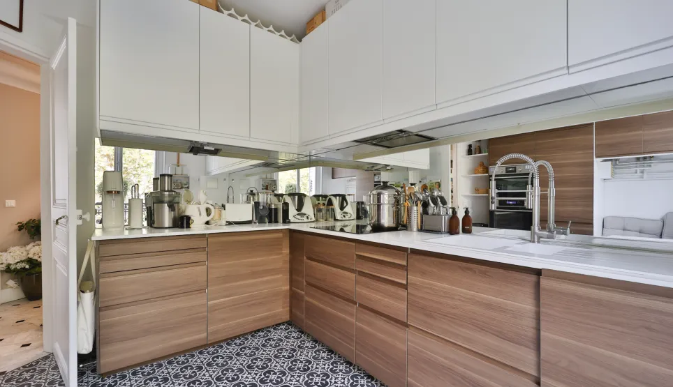 Modern luxury kitchen featuring wood and white cabinetry, sleek countertops, integrated appliances, and designer tiles. Elegant and bright ambiance.