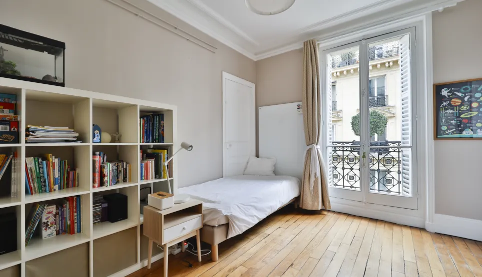 Luminous Parisian studio with hardwood floors, cozy bed, ample storage, and charming balcony. Optimized, elegant living space.