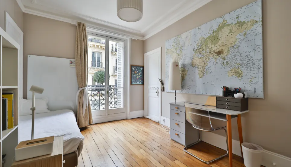 Elegant Parisian bedroom, hardwood floors, balcony, desk. Perfect luxury pied-à-terre in the heart of Paris.