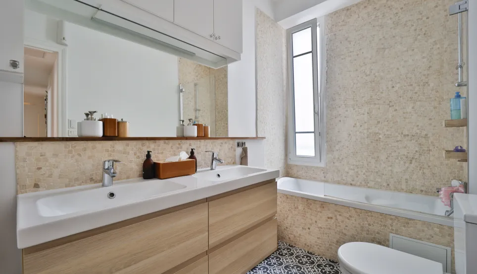 Modern luxury bathroom design: double vanity, wood cabinet, mosaic wall, bathtub, and cement tile floor. Refined and elegant atmosphere.