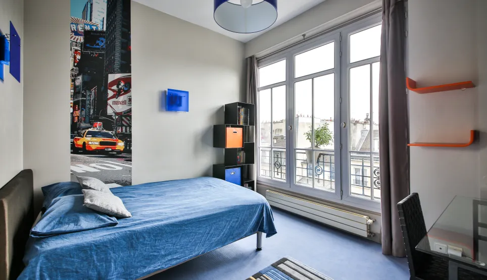 Luxury apartment bedroom: modern, bright, city view. Features a comfortable bed, contemporary design, and urban chic decor with Times Square mural.