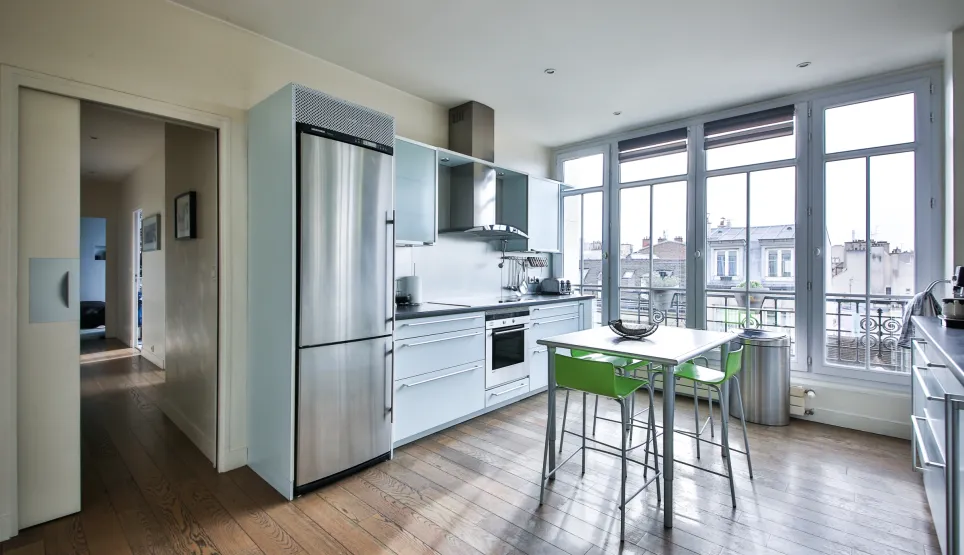 Bright, modern kitchen with stainless steel appliances, hardwood floors. Large bay windows with city views. Luxury apartment, functional design.