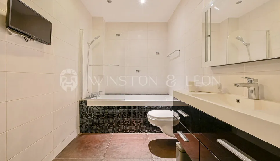 Modern bathroom with bathtub, shower, toilet, and vanity. Sleek design, luxury finishes.