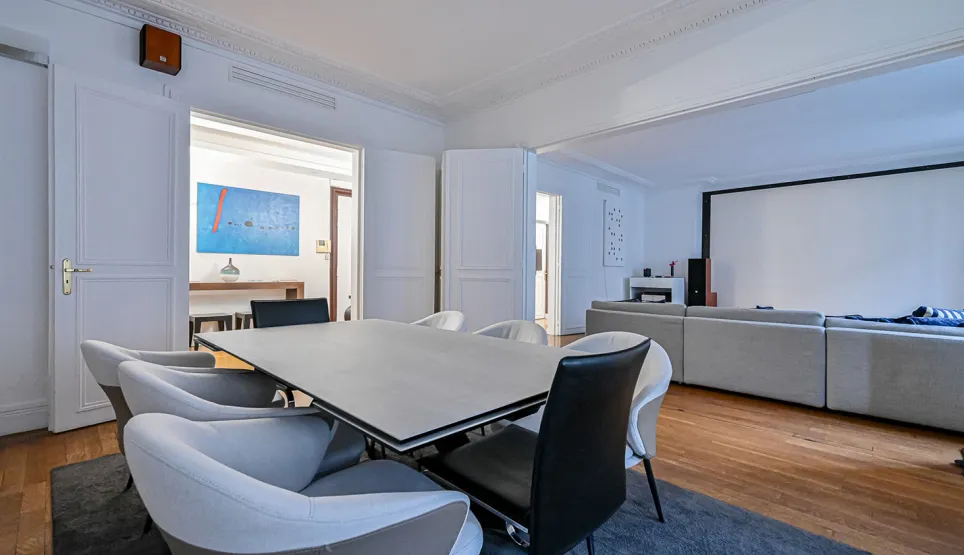 Modern dining room open to home cinema living area. Luxury spacious interior with hardwood floors. Elegant design and comfort.