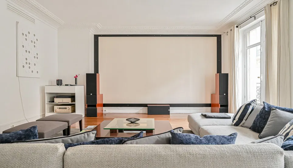 Luxury living room featuring integrated home cinema, large projection screen, and comfortable sofas. Ideal for high-end entertainment and movie nights.