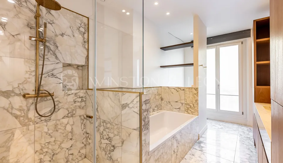 Luxury marble bathroom, walk-in shower, bathtub, gold fixtures. Modern, elegant design for prestigious real estate.