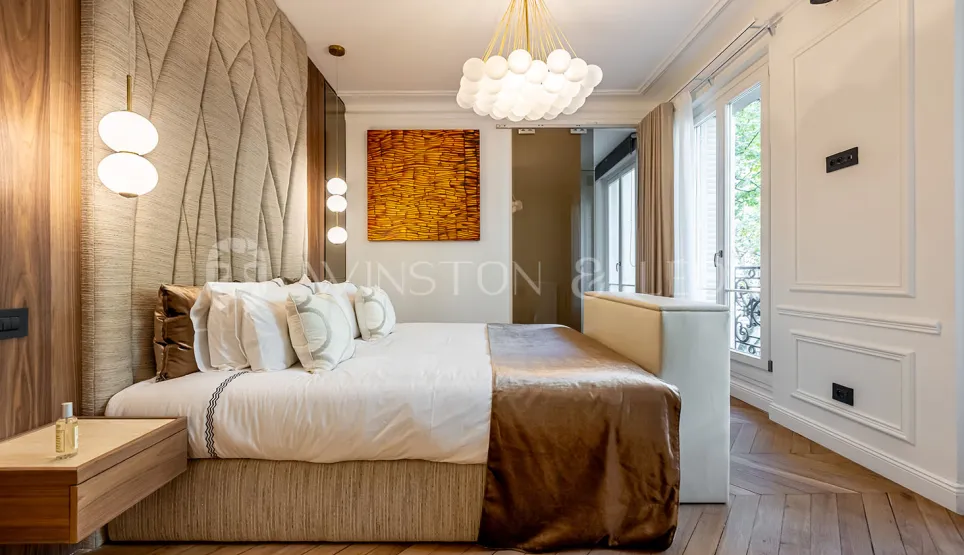 Luxury Parisian bedroom with modern design, textured headboard, parquet, elegant lighting. Comfort and style for an exceptional apartment.