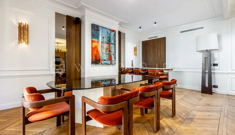 Modern luxury interior: elegant dining room with glass table, orange velvet chairs, contemporary art, and parquet. Refined design.