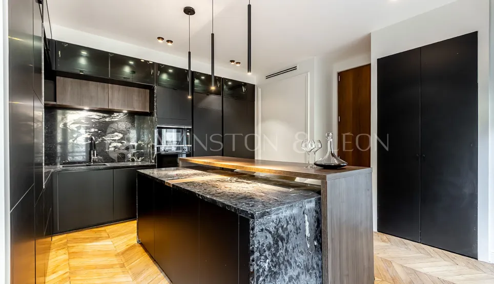 Contemporary luxury black kitchen, marble island, wood, parquet. Elegant and sophisticated design for a high-end interior.
