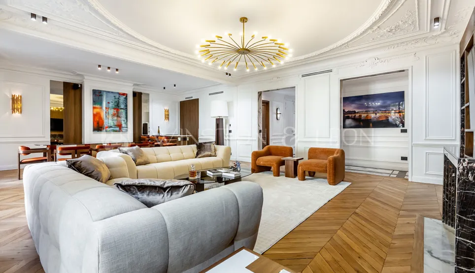 Stunning Parisian luxury apartment living room. Modernized Haussmannian style, designer furniture, parquet, moldings, contemporary chandelier.