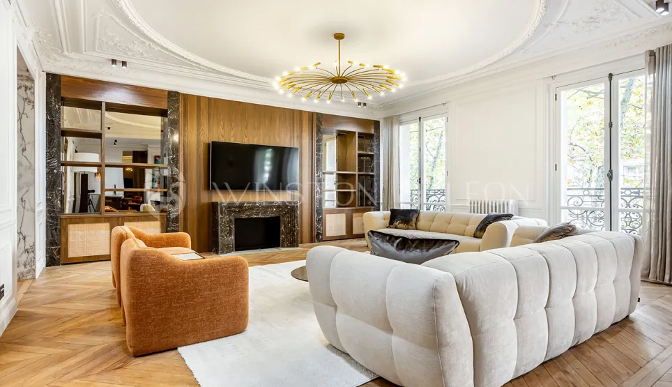 Stunning luxury living room: modern design, marble fireplace, parquet, moldings, designer sofas. Bright and refined ambiance for Parisian apartment.