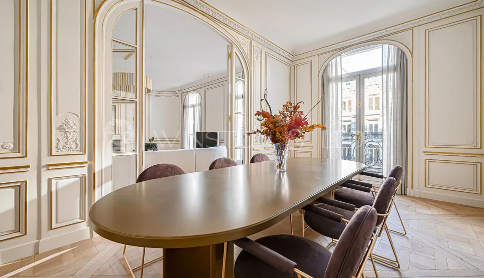 Luxury Parisian dining room: gold mouldings, parquet flooring, contemporary design. Elegance and prestige for an exceptional apartment.