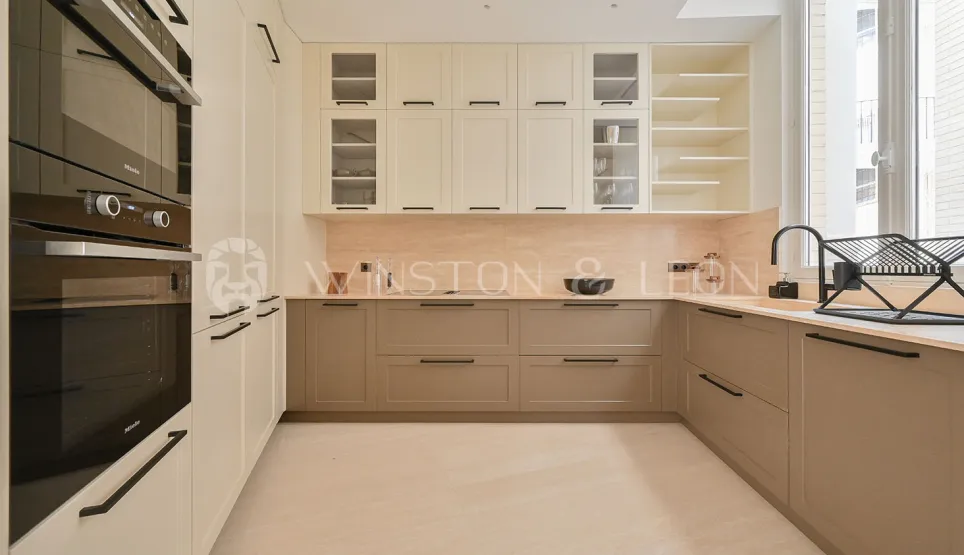 Modern luxury kitchen: two-tone (cream/taupe) design, integrated Miele appliances. Elegant & functional high-end space.