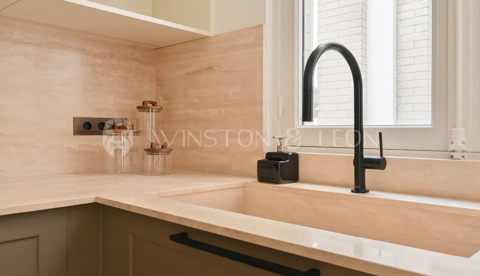 Luxury kitchen: integrated natural stone sink, matte black faucet, elegant countertop. Modern and minimalist ambiance.