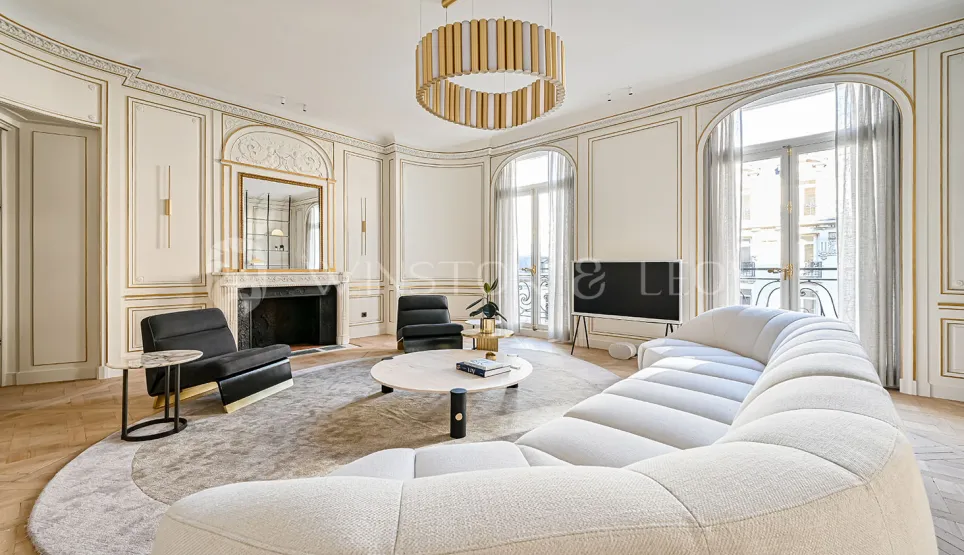 Luxury Parisian living room. Modern & classic Haussmannian design, gold moldings, contemporary sofa. Elegant and refined.