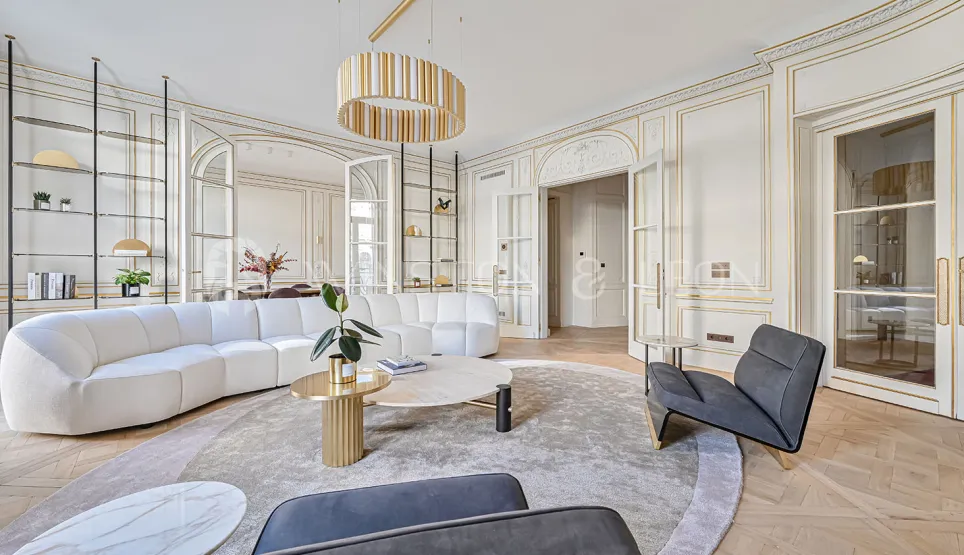 Luxury contemporary living room, gold mouldings, designer sofa, herringbone parquet. Bright Parisian elegance and refinement.