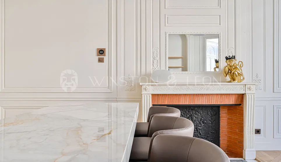 Luxury Parisian interior: marble table, classic fireplace, moldings. Timeless elegance for a high-end property.