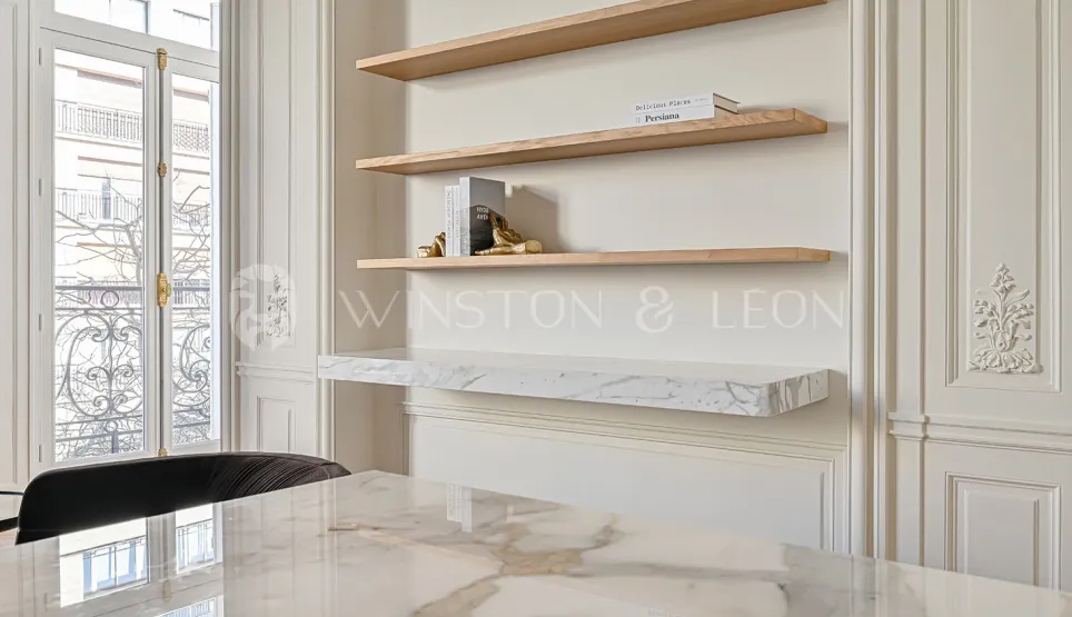 Stunning luxury interior design: marble table, wood shelves, elegant paneling, Haussmannian window. Refinement & brightness for exceptional property.