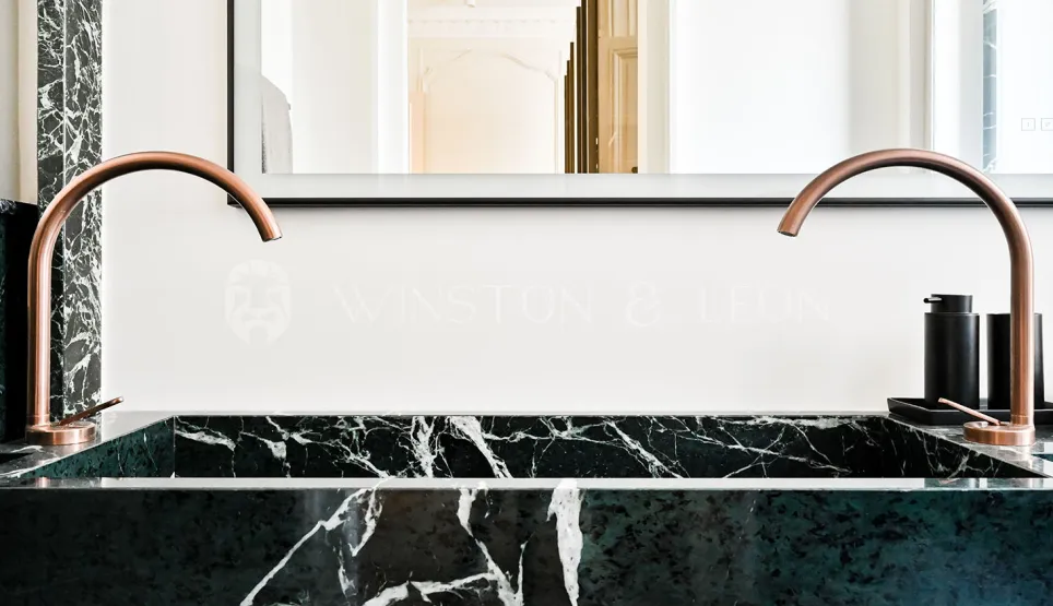 Luxury bathroom: double green marble vanity, designer copper faucets. Modern elegance for a refined interior.