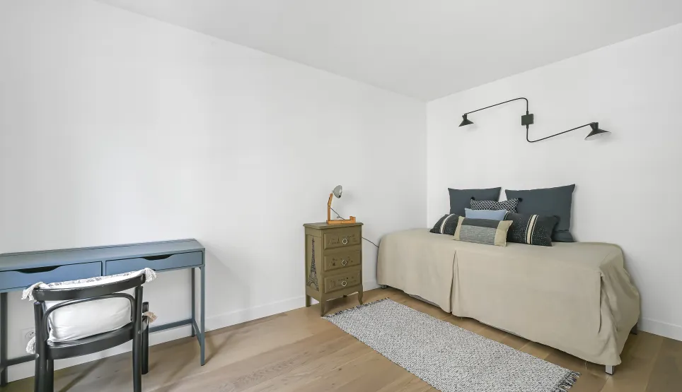 Minimalist, bright bedroom/office. Light wood floor, design bed, elegant desk. Refined versatile space for your luxury property.