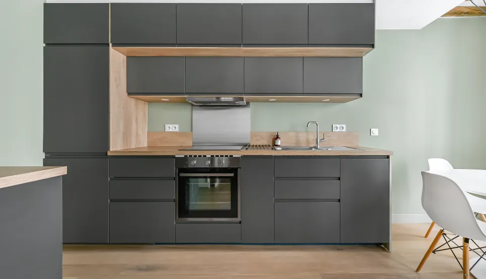 Modern luxury kitchen: charcoal grey, light wood. Sleek, functional design.