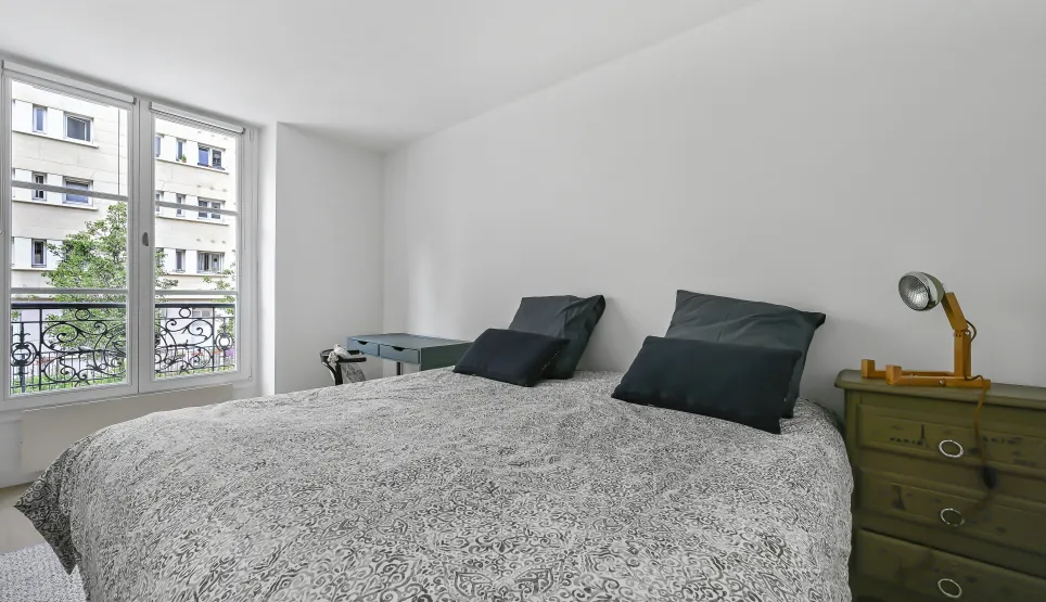Luminous master bedroom, sleek design, urban view, wrought iron balcony. Comfort and elegance for your luxury apartment.