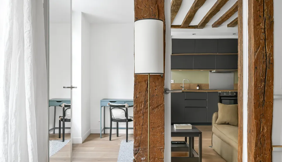 Luxury renovated interior: exposed beams, modern kitchen, elegant design. Old charm meets contemporary comfort.