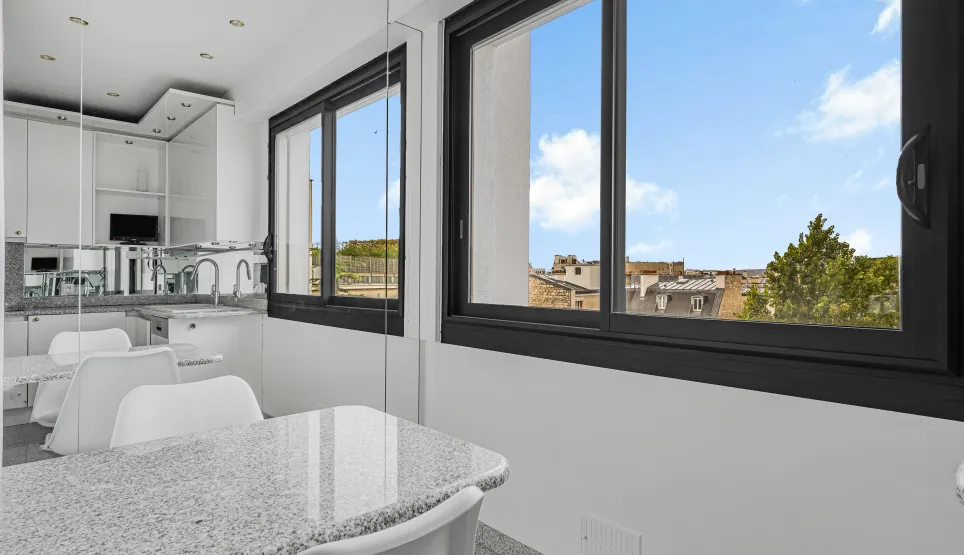 Bright modern kitchen, granite island, urban view. Sleek design for a contemporary luxury apartment.