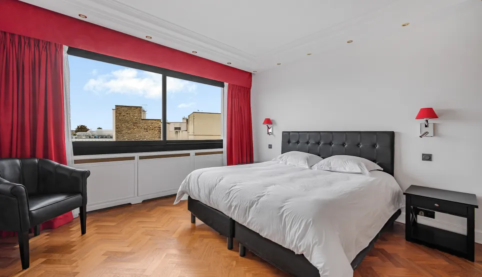 Bright luxury bedroom, city view, herringbone parquet. Elegant double bed, armchair. Perfect for high-end real estate.