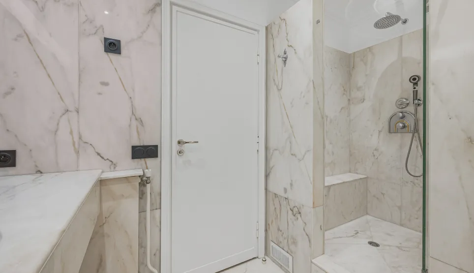 Luxury marble bathroom with modern walk-in shower. Elegant and contemporary design for high-end real estate.