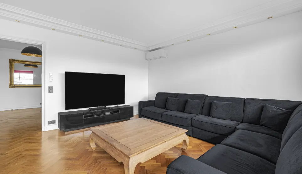 Modern luxury living room with large sectional sofa, TV, herringbone parquet. Comfort and elegance for your home.