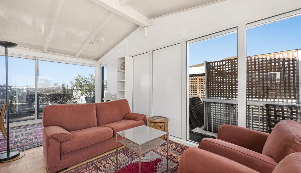 Bright penthouse living room with terrace view, large bay windows. Luxury apartment, modern comfortable space. Ideal urban living.