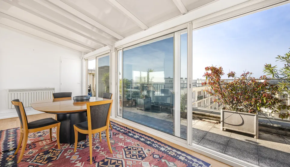 Bright solarium/veranda dining area with direct access to a private rooftop terrace offering open city views. Perfect for a luxury penthouse.