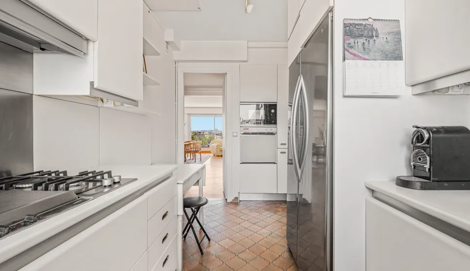 Bright modern kitchen, integrated appliances, unique tiled floor. Open view from living room. Ideal luxury apartment, comfort and style.