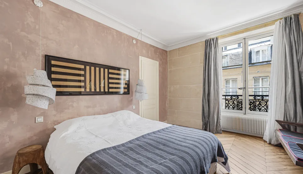 Luxury Parisian bedroom. Modern design, textured walls, parquet flooring, city view. Elegant and refined ambiance.
