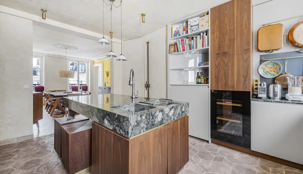 Luxury kitchen with marble and wood island, modern and elegant design. Open space to dining room. Haussmannian apartment.