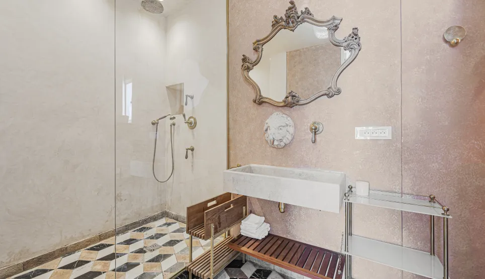 Luxury bathroom. Glass shower, baroque mirror, stone sink, geometric marble floor. Elegant and refined design.