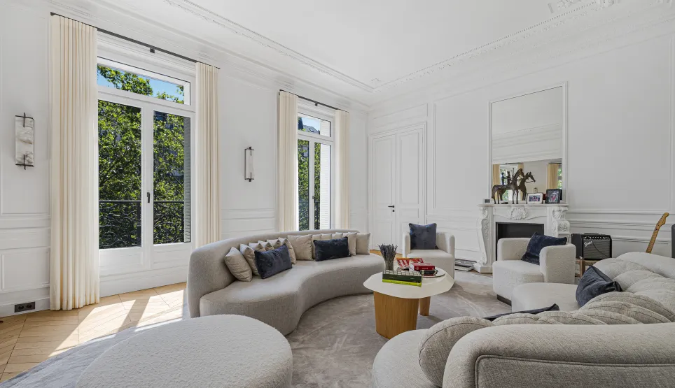 Modern luxury living room, bright. Curved designer sofas, Parisian elegance, green views.