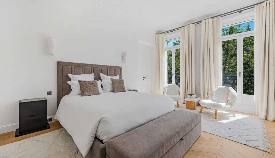 Luxury master bedroom, elegant design, green views. Refined comfort for prestige real estate. High-end apartment.