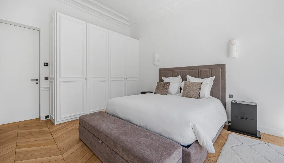 Contemporary luxury bedroom, minimalist design. Comfortable bed, built-in closet, hardwood floor. Bright and elegant ambiance.