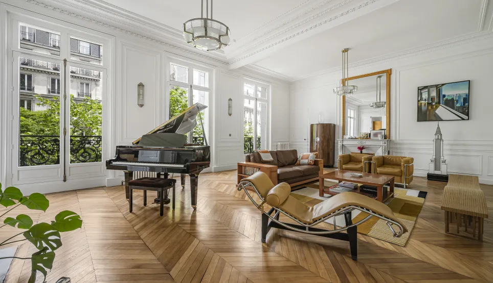 Luxury Parisian living room with grand piano, herringbone parquet, moldings & green views. Timeless elegance & design.