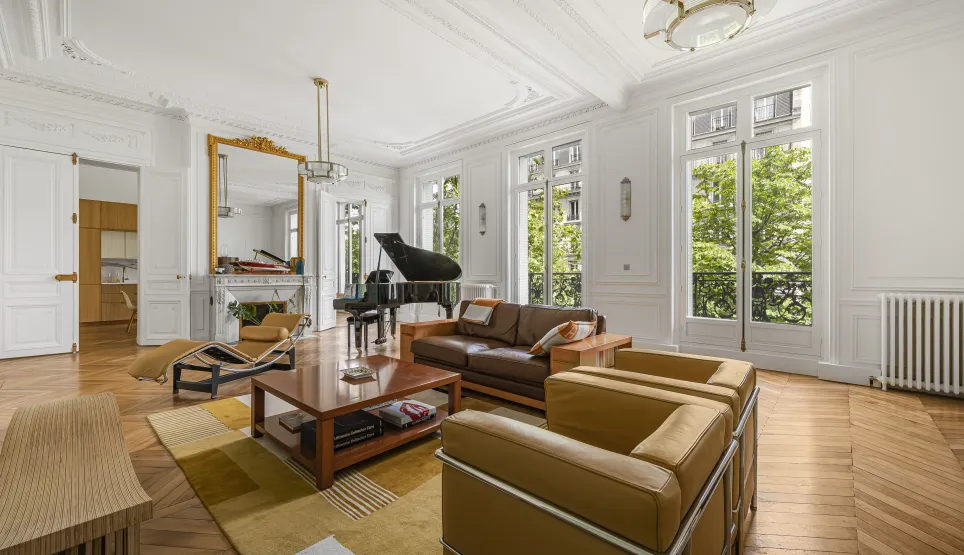 Luxury Parisian Haussmannian living room: grand piano, parquet, mouldings, fireplace, green view. Elegant & bright.