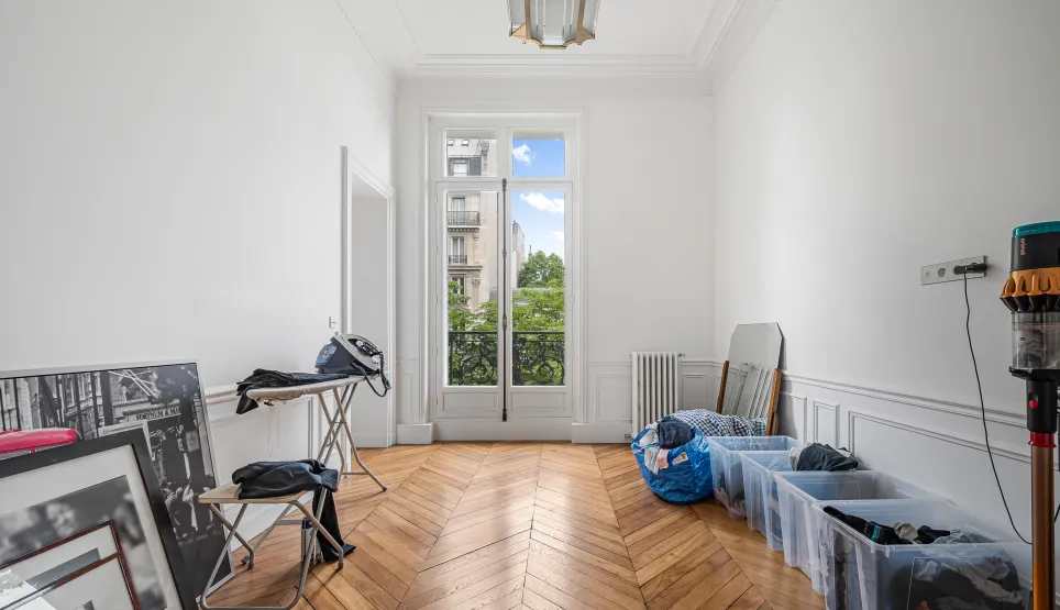 Bright Parisian Haussmann apartment. Herringbone parquet, moldings, balcony window. Luxury potential, green view.