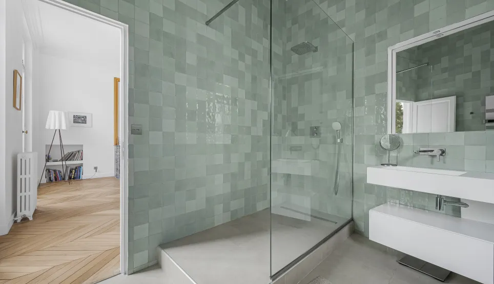 Modern luxury bathroom with walk-in shower and elegant mint green zellige tiles. High-end design for a sophisticated apartment.