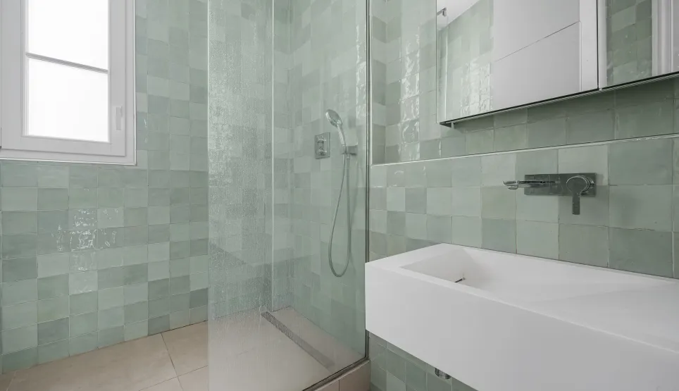 Luxury modern bathroom. Walk-in shower, mint green zellige tiles, designer basin. Elegant and refined design for a high-end interior.