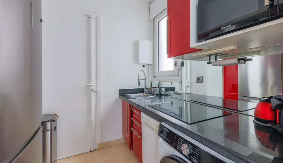 Modern, elegant, fully equipped kitchen (washer, microwave), contemporary red and black design. Ideal for luxury apartment.