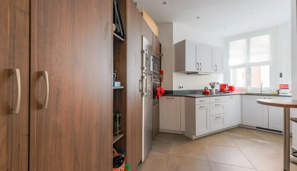 Bright, modern kitchen with elegant wood cabinetry, integrated stainless steel appliances, and high-end finishes. Perfect for luxury real estate.