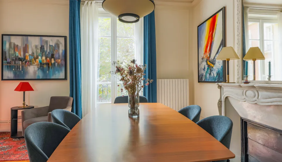 Elegant, bright dining room with modern design and artistic touches. A refined space with fireplace for luxury property.